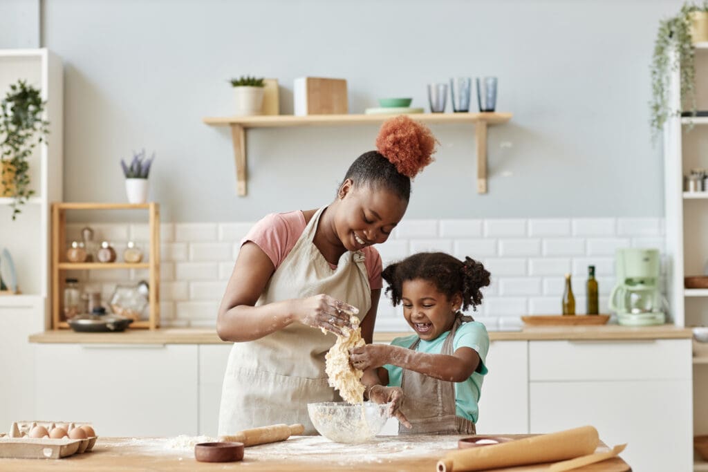 Mother and child baking and smiling.