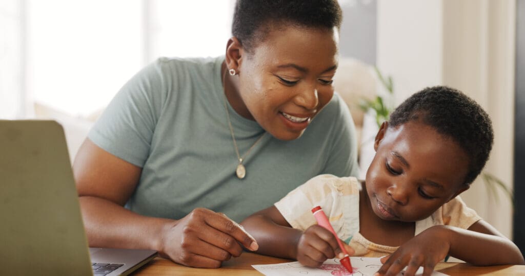 Mother and child coloring with red crayon.