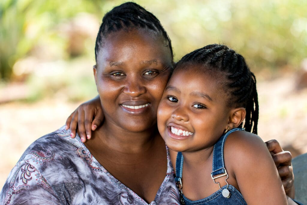 Mother and child embracing outdoors.